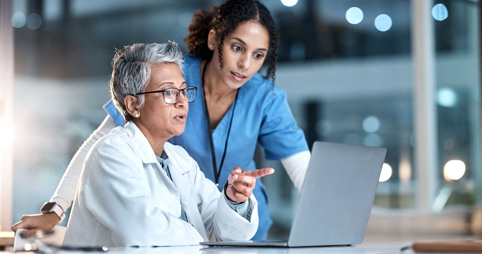 Medical staff reviewing billing and coding on computer